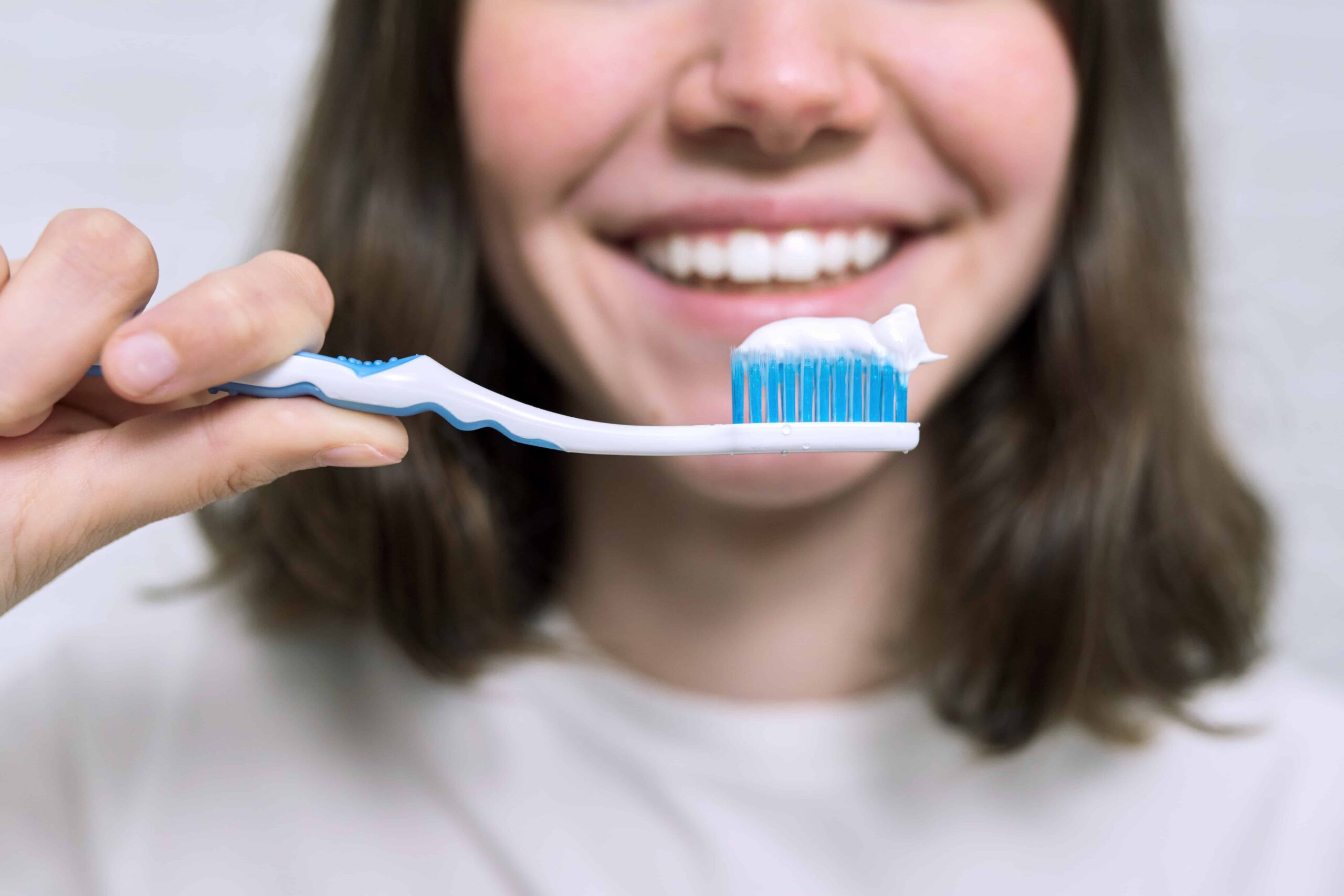 close-up-teenager-girl-with-toothpaste-brush-brushing-her-teeth-bathroom-morning-evening-dental-hygiene